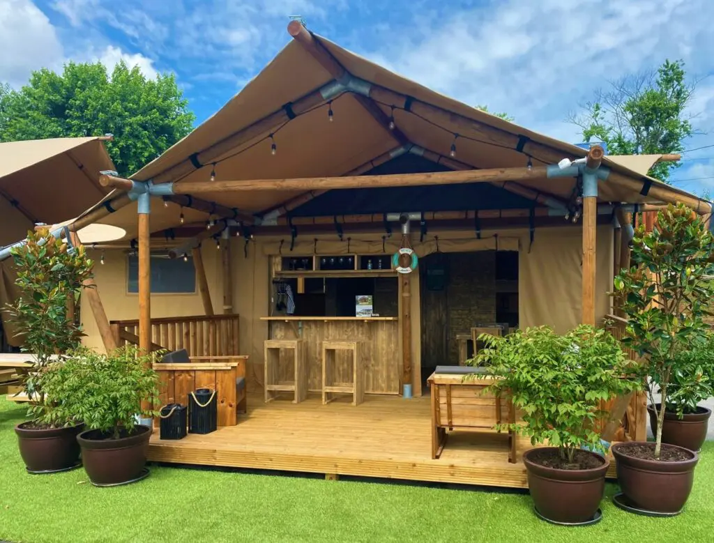 Safari Cantina Tent with durable canvas Front facing right tilted. Blue skies with green grass.