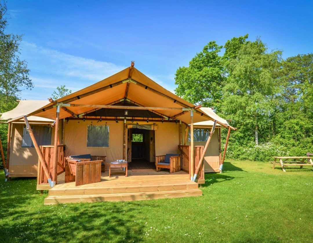 Dreamer Luxury Glamping Tent Forward Facing. Beautiful blue skyline with trees in the background.